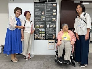 ポスターの前で、発表した4人の写真